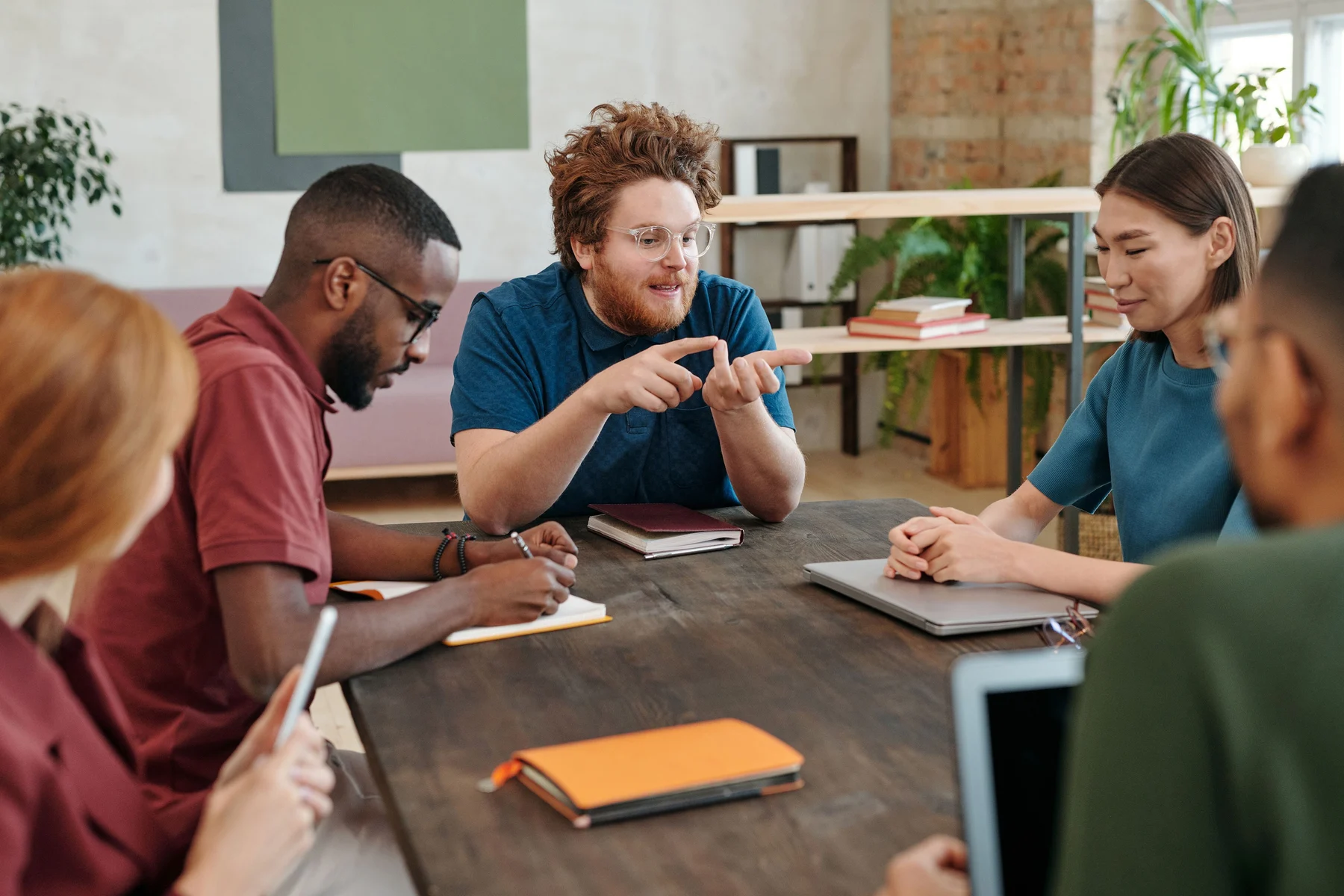 Editorial photograph of colleagues sharing ideas around a table