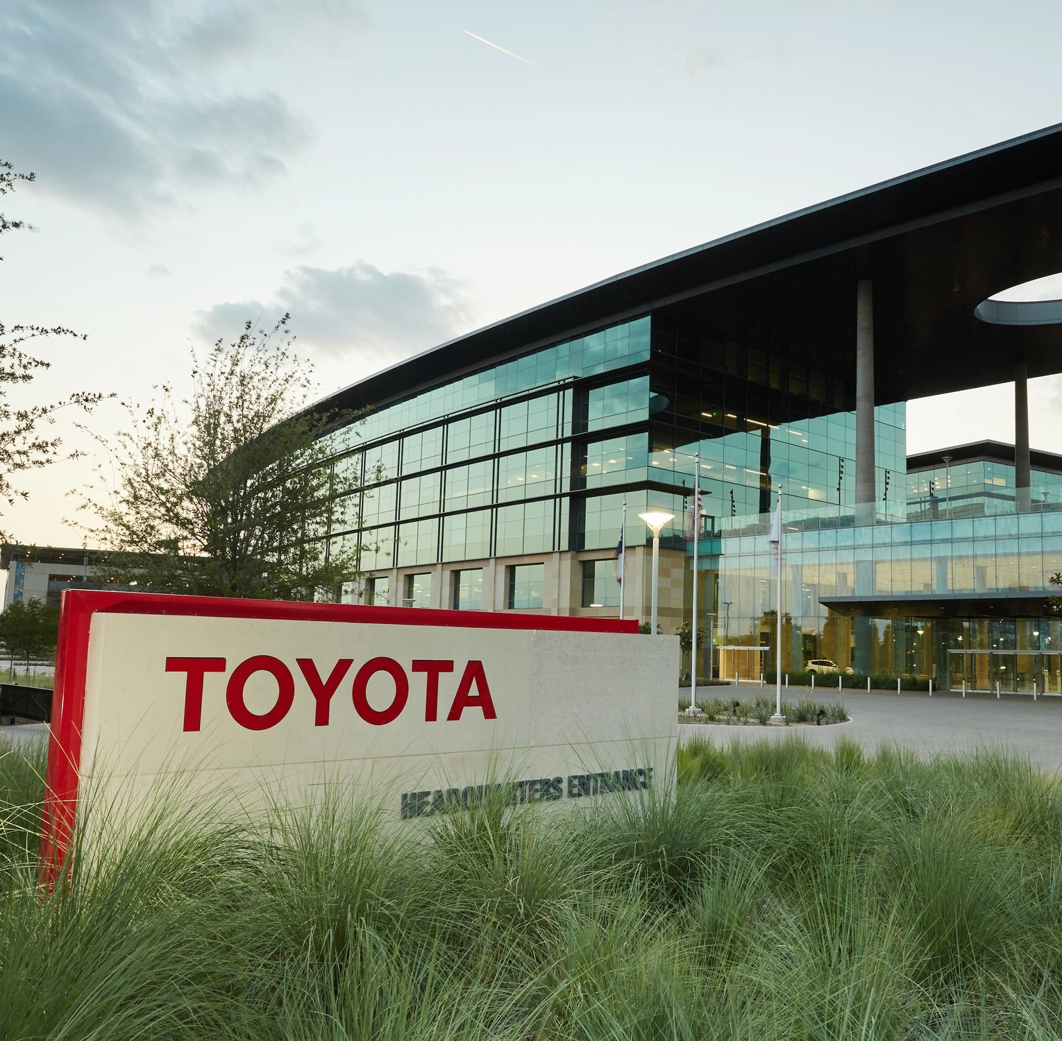 Toyota headquarters entrance signage beside the glass campus building
