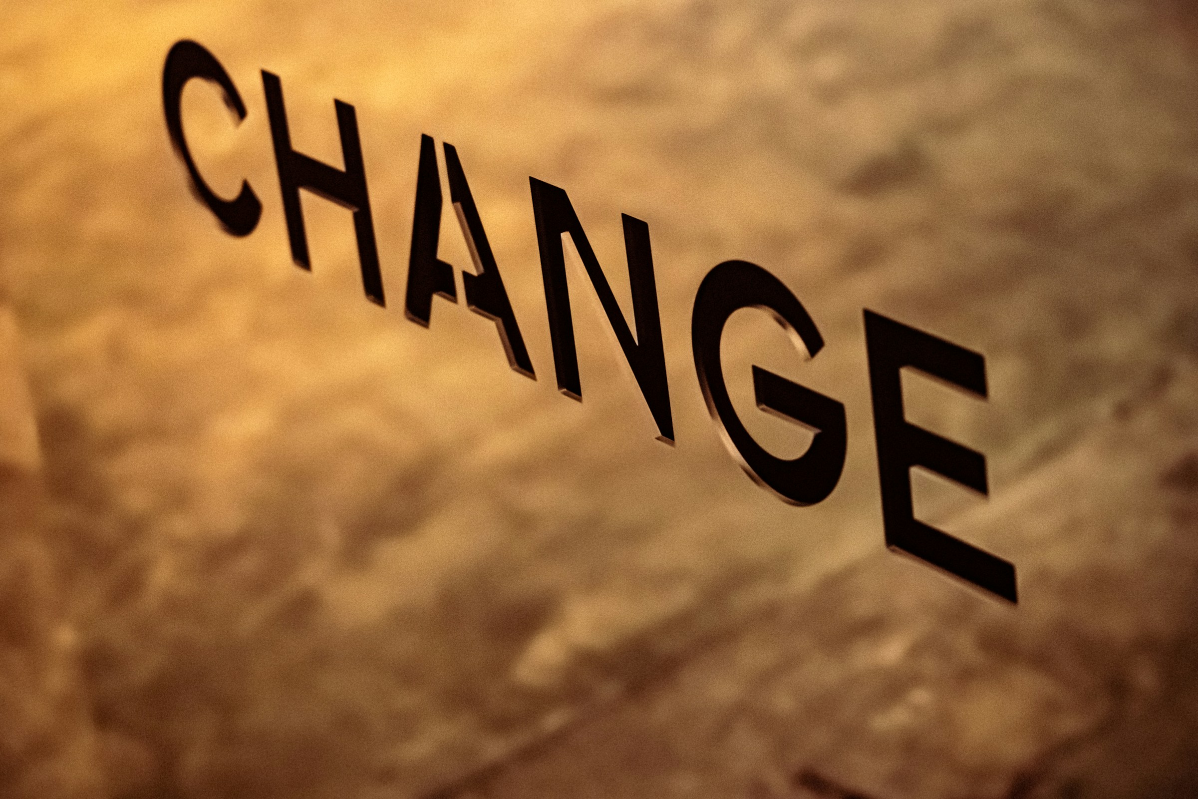 The word change in bold black lettering on a textured surface