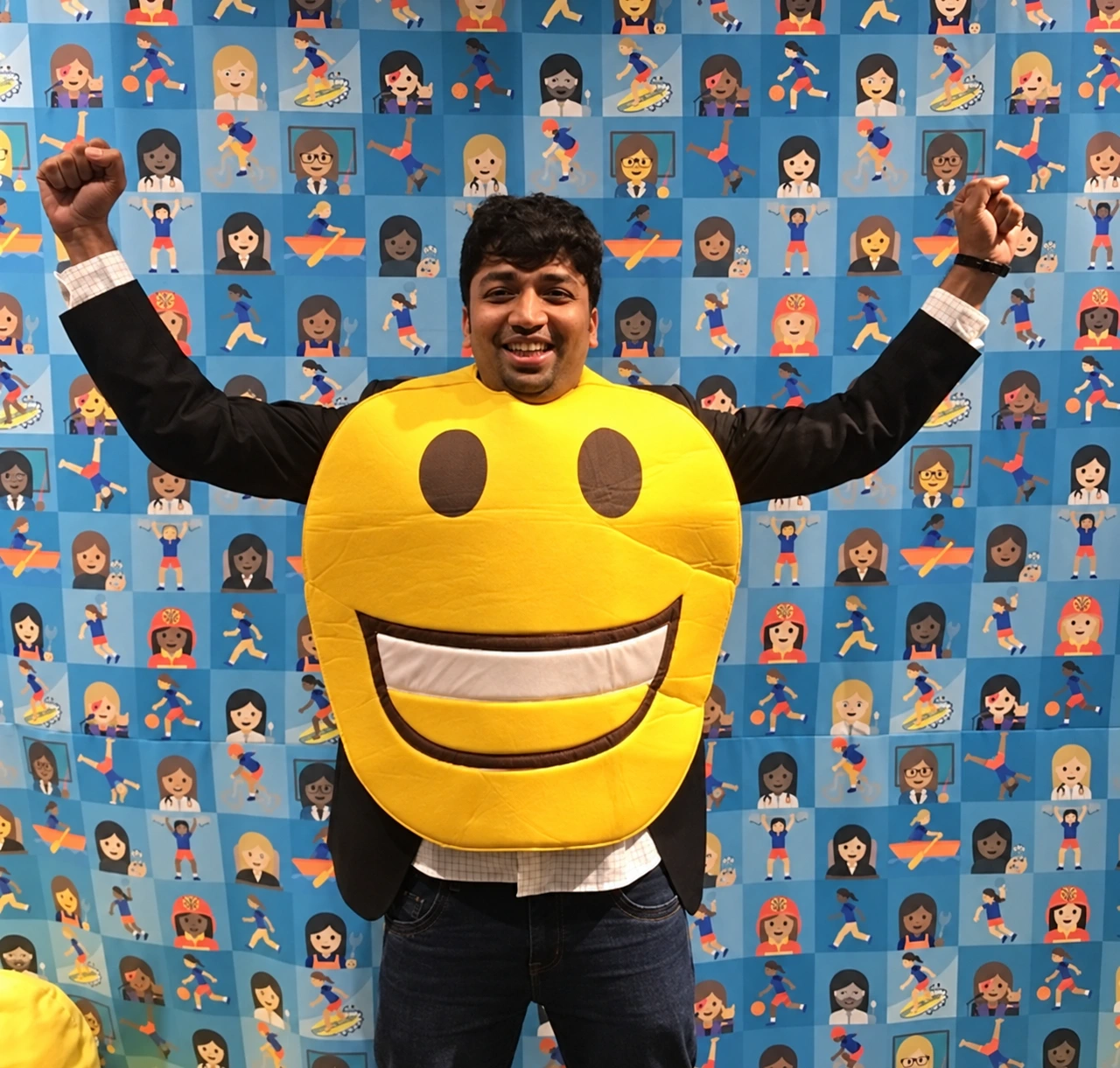 Enhanced archive photo of Sumesh in a yellow emoji costume at Emojicon